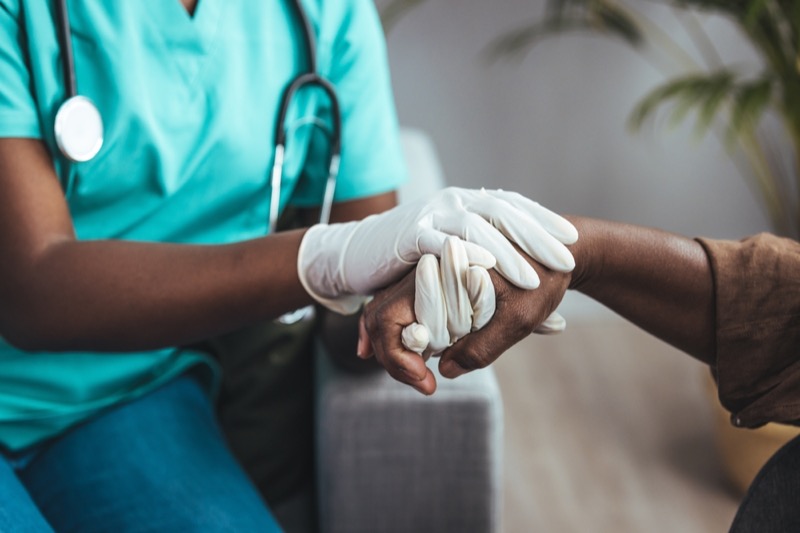 Female Nurse Hold Hands of Senior Patient