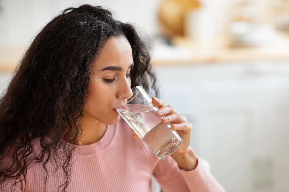 Thirsty Young Lady Enjoying Refreshing Drink At Home