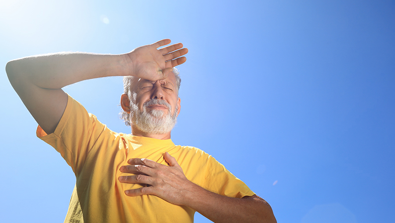 Senior man suffering from heat stroke outdoors