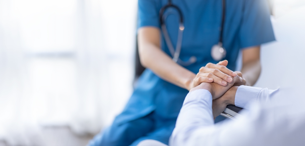 Cropped shot of a female nurse hold her senior patient's hand.