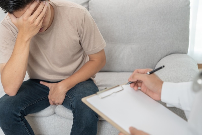 Man hold hand in front of private parts feeling discomfort and consult doctor.