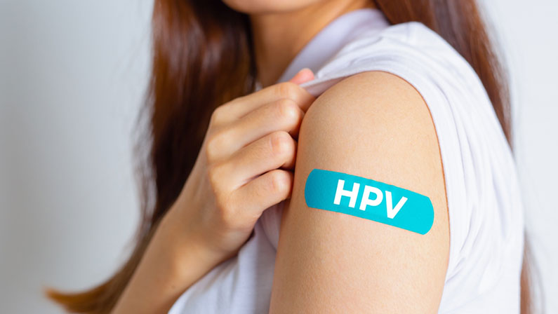 HPV (Human Papillomavirus) Teenager woman showing off an blue bandage after receiving the HPV vaccine