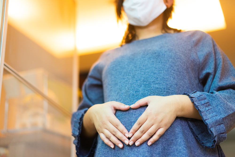 woman mom with mask for protection tummy baby.lockdown