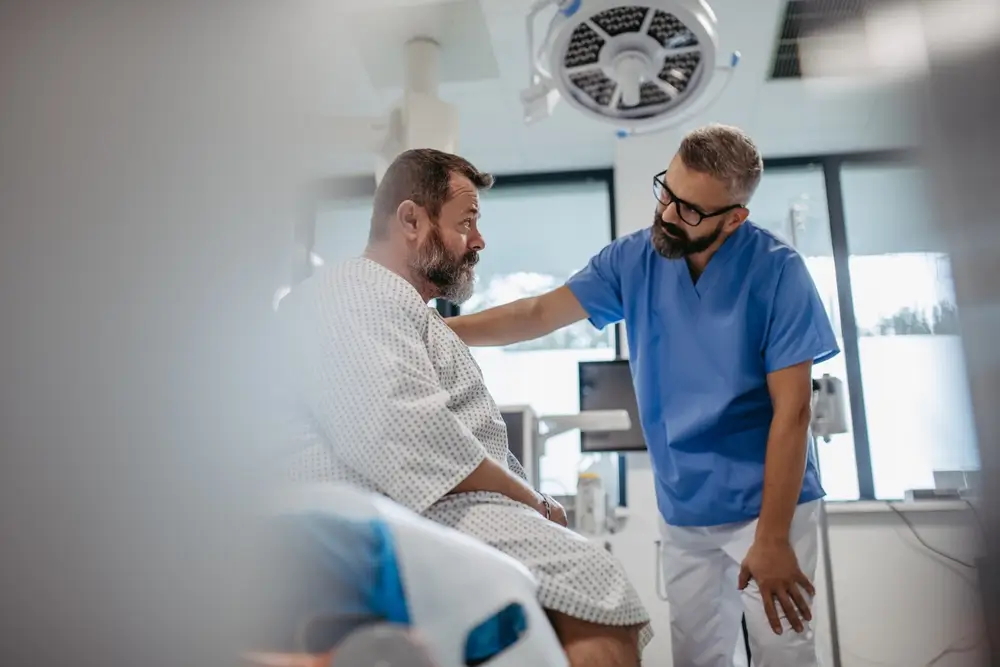 Supportive doctor soothing a worried overweight patient, discussing test result in emergency room. 